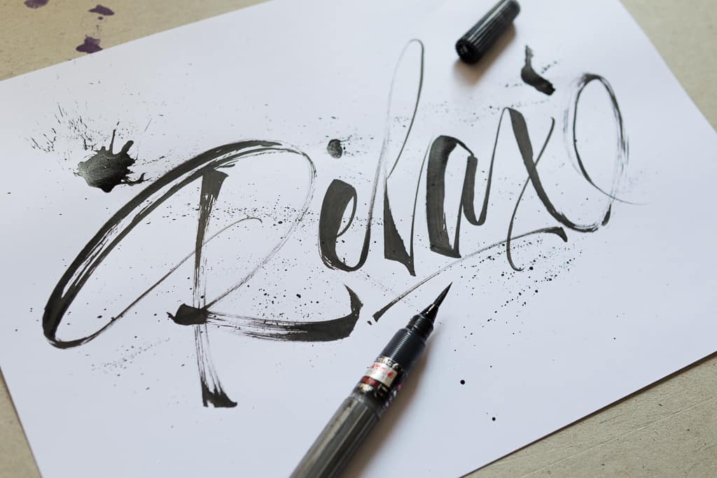 Word relax written in calligraphy using a brush pen. 
