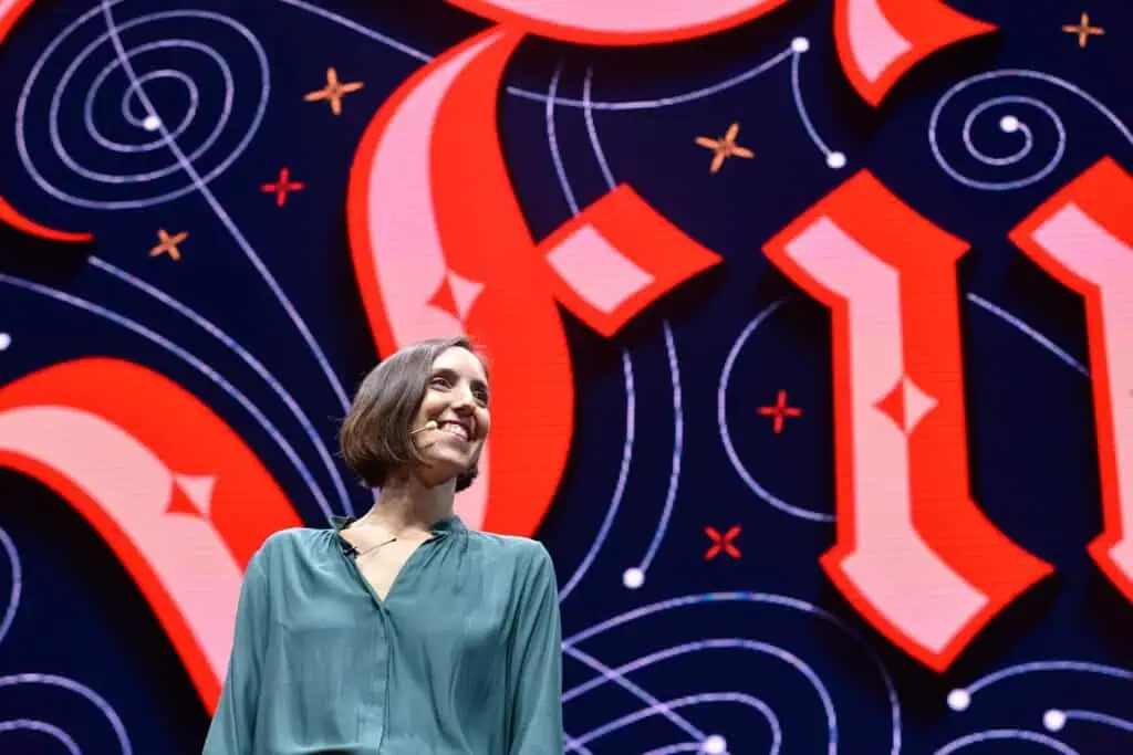 Smiling speaker in front of colorful backdrop