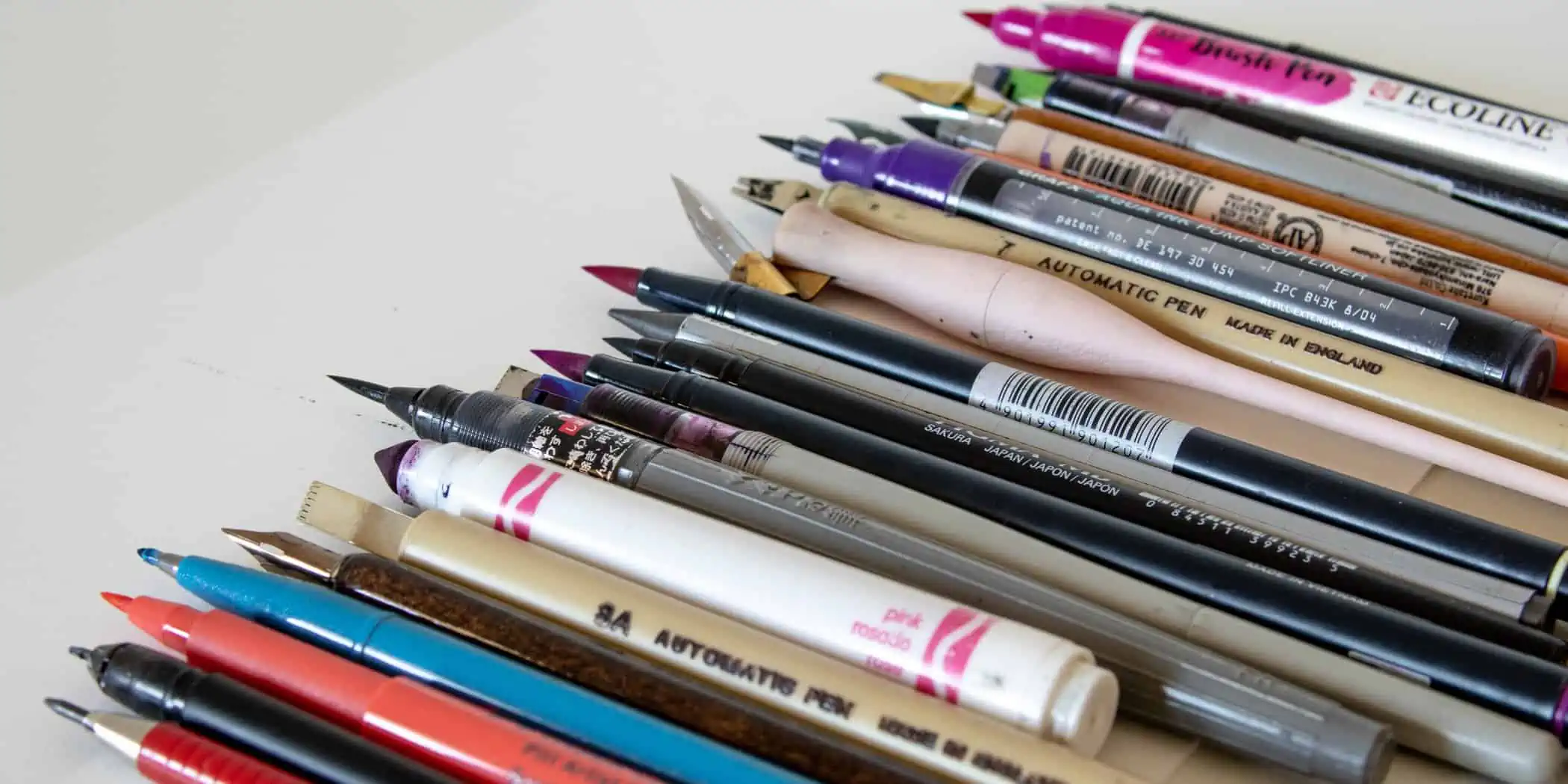 Various colorful art pens and markers arranged neatly