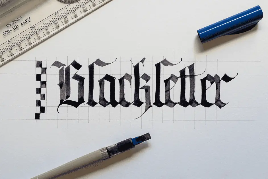 Blackletter calligraphy in progress with tools