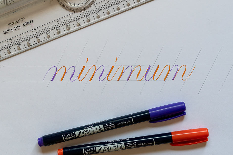 The word minimum written in calligraphy with two brush pens in different colors. 