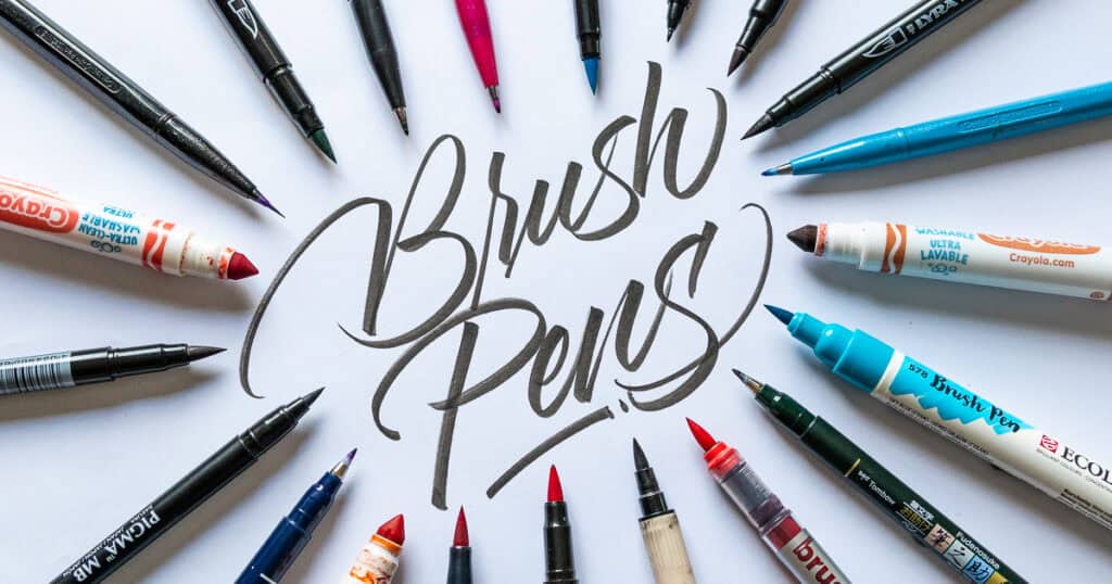 Various brush pens surrounding handwritten text.