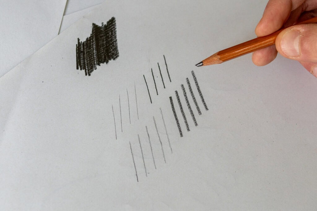 Hand drawing pencil strokes on paper