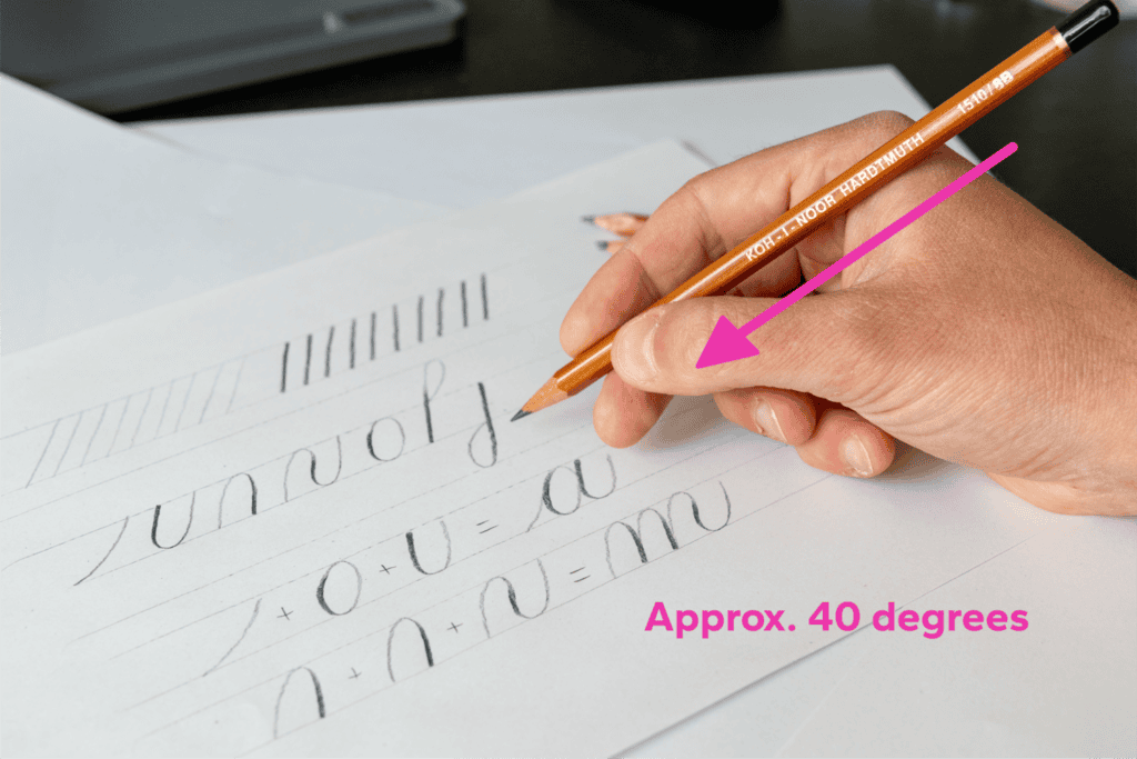 Hand demonstrating cursive pencil writing technique.