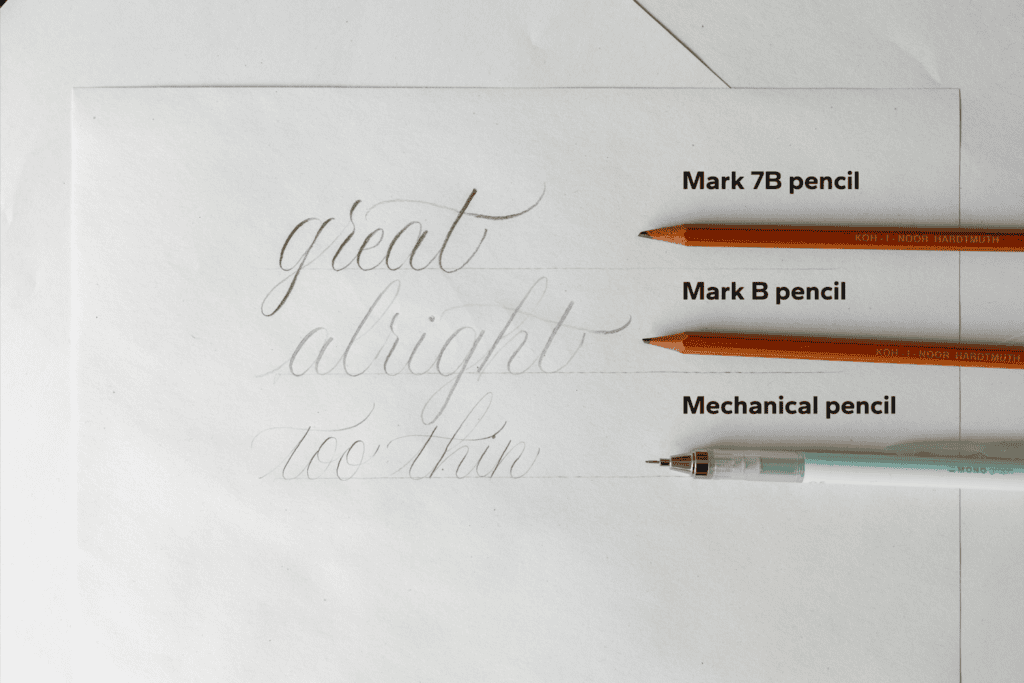 Pencils and calligraphy examples on paper.