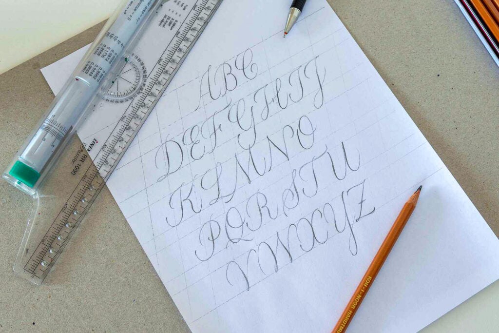 Paper with cursive alphabet practice and drawing tools.