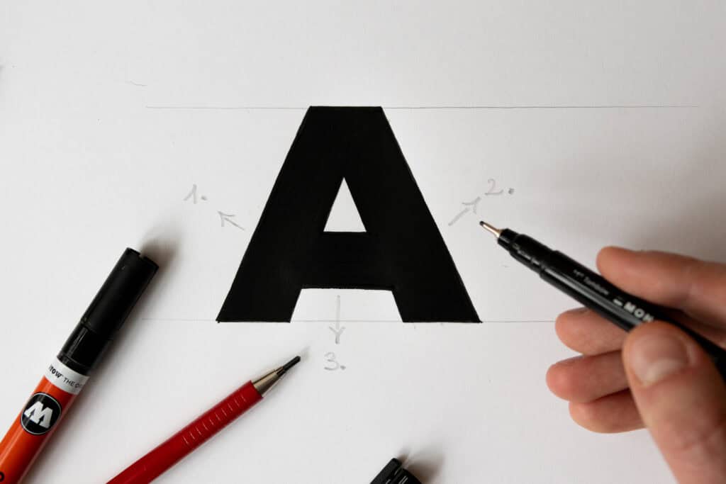Hand painting a large black letter A.