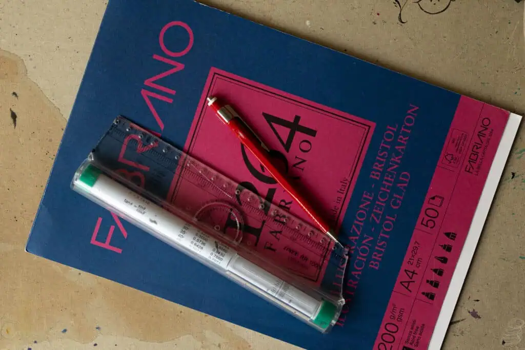 Ruler, pen, and sketch paper on workspace.